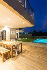 a patio with a table and chairs and a swimming pool at LUXURIOUS NEW HOUSE, UNFORGETABLE EXPERIENCE. in Canoa Quebrada