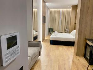 a hotel room with a bed and a couch and a tv at ELMAR HOTEL in Vlorë