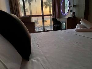 a bed in a hotel room with a large window at ELMAR HOTEL in Vlorë