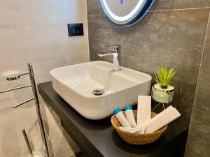 a bathroom sink with a basket of toothbrushes at ELMAR HOTEL in Vlorë