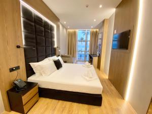 a bedroom with a large bed and a television at ELMAR HOTEL in Vlorë