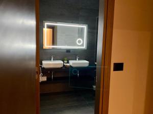 a bathroom with two sinks and a mirror at ELMAR HOTEL in Vlorë