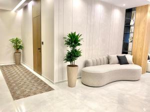a living room with a couch and two potted plants at ELMAR HOTEL in Vlorë
