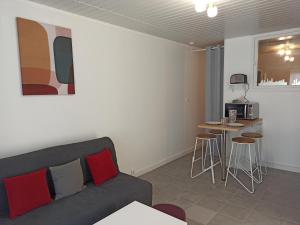 a living room with a couch and a table and a kitchen at Le Saint-Jacques - Hypercentre in Châtellerault