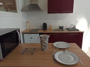 a kitchen with a wooden table with plates on it at Le Saint-Jacques - Hypercentre in Châtellerault