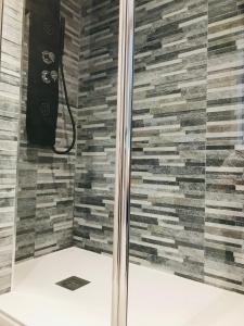 a shower in a bathroom with a stone wall at lucushouse III in Lugo