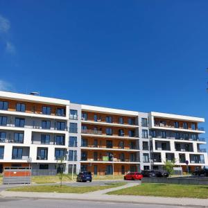 a large apartment building with cars parked in front of it at Silver 58 Zator in Zator