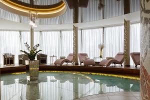 una piscina nella hall dell'hotel con sedie e tavolo di Aroma Stone Hotel Spa a Syców