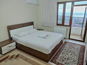 a bedroom with a bed and a large window at Bahardali Suites - شقق غصن الربيع in Trabzon