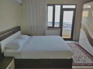 a bedroom with a large white bed and a window at Bahardali Suites - شقق غصن الربيع in Trabzon +21 photos