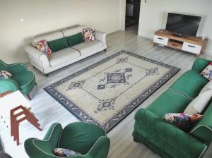 a living room with two green couches and a rug at Bahardali Suites - شقق غصن الربيع in Trabzon