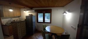 a small kitchen with a table and a refrigerator at Villa on the lake near Mostar in Jablanica