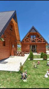 duży drewniany budynek z ogródkiem przed nim w obiekcie Big bear villas w mieście Žabljak