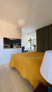 ein Schlafzimmer mit einem Bett mit gelber Tagesdecke in der Unterkunft ApartmentInCopenhagen Apartment 1499 in Kopenhagen