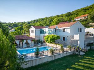 uma villa com uma piscina e uma casa em Krolo Villa&Wine em Trilj