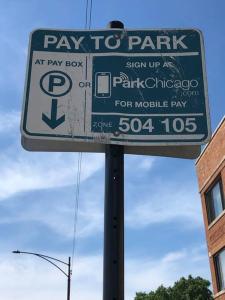a pay to park parking sign on a pole at The Blue Golden Luxury Modern 3- Bedroom Apartment in Chicago in Chicago
