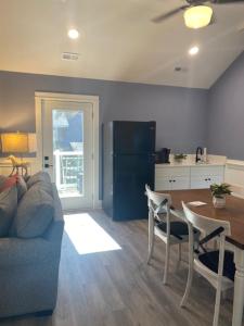 a living room with a couch and a table and a kitchen at Wild Horse Inn in Corolla