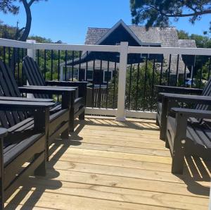 a wooden deck with two benches and a fence at Wild Horse Inn in Corolla