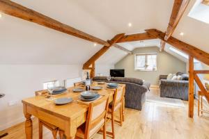 a kitchen and living room with a wooden table and chairs at Upstairs Downstairs Cottage in Snainton