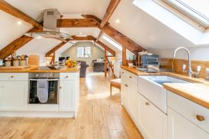 a kitchen with white cabinets and a ceiling with skylights at Upstairs Downstairs Cottage in Snainton