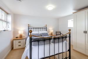 a bedroom with a black bed in a room at Upstairs Downstairs Cottage in Snainton