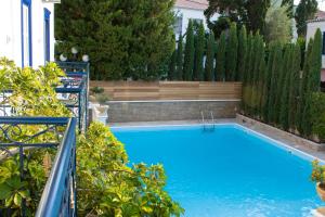 a swimming pool in a backyard with a fence and trees at Armata Boutique Hotel in Spetses
