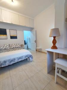 Un dormitorio con una cama y una mesa con una lámpara. en APARTAMENTO PLAYA ALCARAVANERAS, en Las Palmas de Gran Canaria