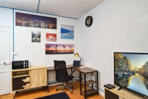 a living room with a desk and a tv at Le Fil Bleu - CENTRE VILLE - ENTIÈREMENT ÉQUIPÉ in Montluçon