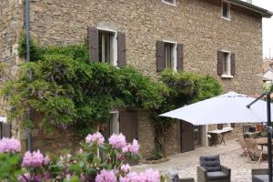 - un parasol blanc devant un bâtiment fleuri dans l'établissement Un Jardin Secret, à Yzeron