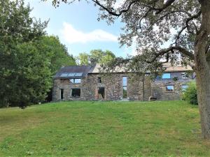 a large stone house with a large grass field at Conviviale - Longère Lumineuse - Charme & Nature in Bains-sur-Oust