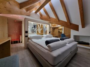 Cama grande en habitación con techo de madera en Hotel Canada, en Andalo