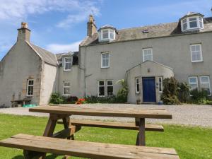 a picnic table in front of a house at The West Wing in Skye of Curr