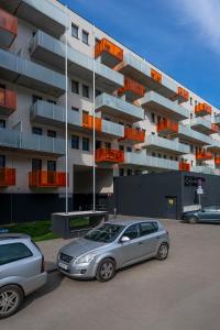 two cars parked in a parking lot in front of a building at Feel At Home in Wrocław