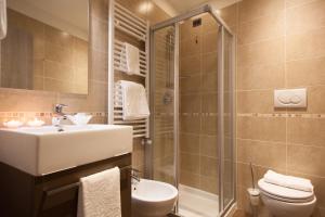 a bathroom with a sink toilet and a shower at Hotel Portici - Romantik & Wellness in Riva del Garda