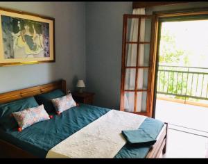 1 dormitorio con cama con sábanas azules y ventana en Valerie's House, en Poros