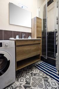 a bathroom with a sink and a washing machine at Le Fil Bleu - CENTRE VILLE - ENTIÈREMENT ÉQUIPÉ in Montluçon