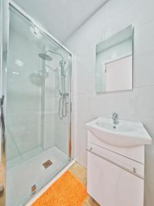 a white bathroom with a sink and a shower at CASA EN LA PLAYA VALENCIA EL PERELLO in Mareny Barraquetas