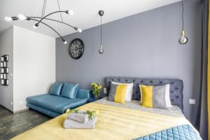 ein Schlafzimmer mit einem Bett und einem blauen Sofa in der Unterkunft Stylowe king studio, metro Słodowiec, parking, park in Warschau