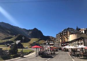 une rue avec des tables et des parasols et un bâtiment dans l'établissement Vue panoramique - 4pers - parking, à La Mongie