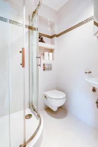 uma casa de banho branca com um chuveiro e um WC. em Sea You Apartments - Chrobrego em Sopot