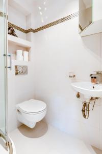 uma casa de banho branca com um WC e um lavatório em Sea You Apartments - Chrobrego em Sopot