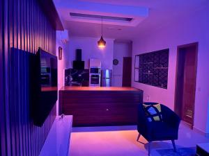 Habitación púrpura con bar con silla en The Zen Loft - 2BR Open Plan Apt W/Pool+Smart Lock, en Lekki