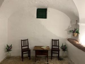 a table and two chairs in a room with a green window at Casa dos Tios in Veiros