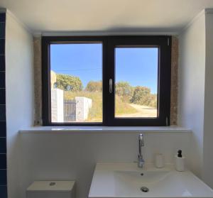 a bathroom with a window above a sink at Casas do Apeadeiro de Evoramonte in Vimieiro +40 photos