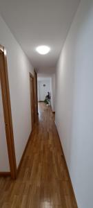 pusty korytarz z drewnianą podłogą i białą ścianą w obiekcie Appartement lumineux T3 avec jardin privatif à Hendaye - Parking et wif gratuit w mieście Hendaye +16 zdjęć