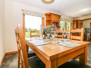 a wooden table in a kitchen with wine glasses at Birchbank in Skye of Curr