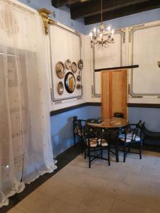 ein Esszimmer mit einem Tisch, Stühlen und einem Kronleuchter in der Unterkunft Casa Dos Gallos in San Sebastián del Oeste