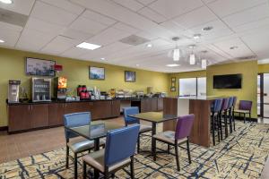 Best Western Plus McDonough Inn & Suites في ماكدونو: غرفة انتظار مع طاولات وكراسي وكاونتر