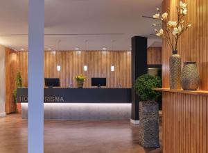 un vestíbulo de oficina con recepción con jarrones en Best Western Hotel Prisma en Neumünster