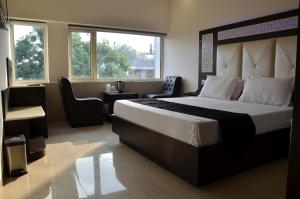 a bedroom with a large bed and a desk and chairs at Hotel Royal Park 22 in Chandīgarh